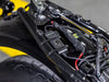 Adaptor cable-tied to the subframe tube of a yellow and black motorcycle, with the labelled USB module hanging below