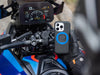 Gloved rider holds an iPhone in the MAG case with a blue ring beside a sports bike's colour dash and bar mount